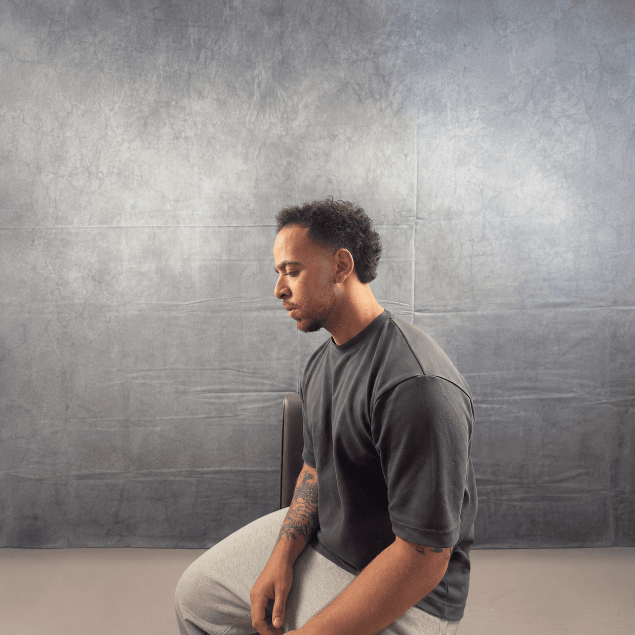 Badawi, founder of Blades Studios, seated against the studio backdrop
